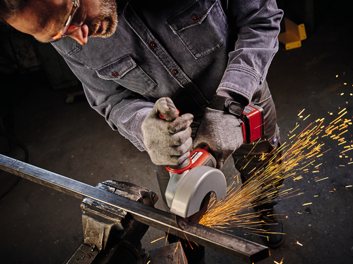 A man is working with a cordless angle grinder