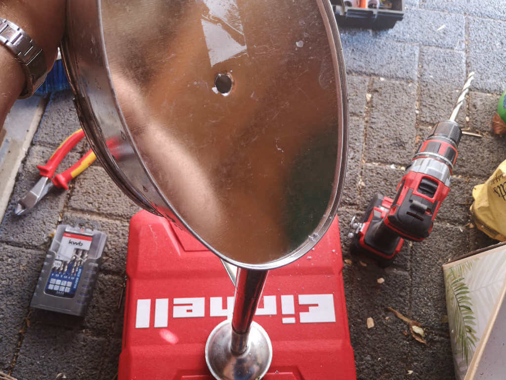 Watering can with predrilled hole