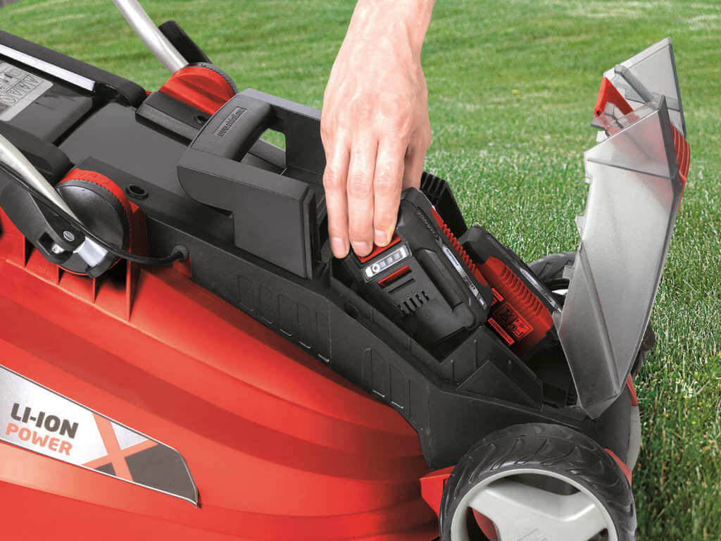 Battery getting placed into the lawn mower. 