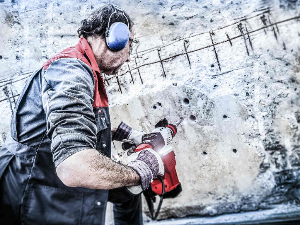 man working with driller in concrete